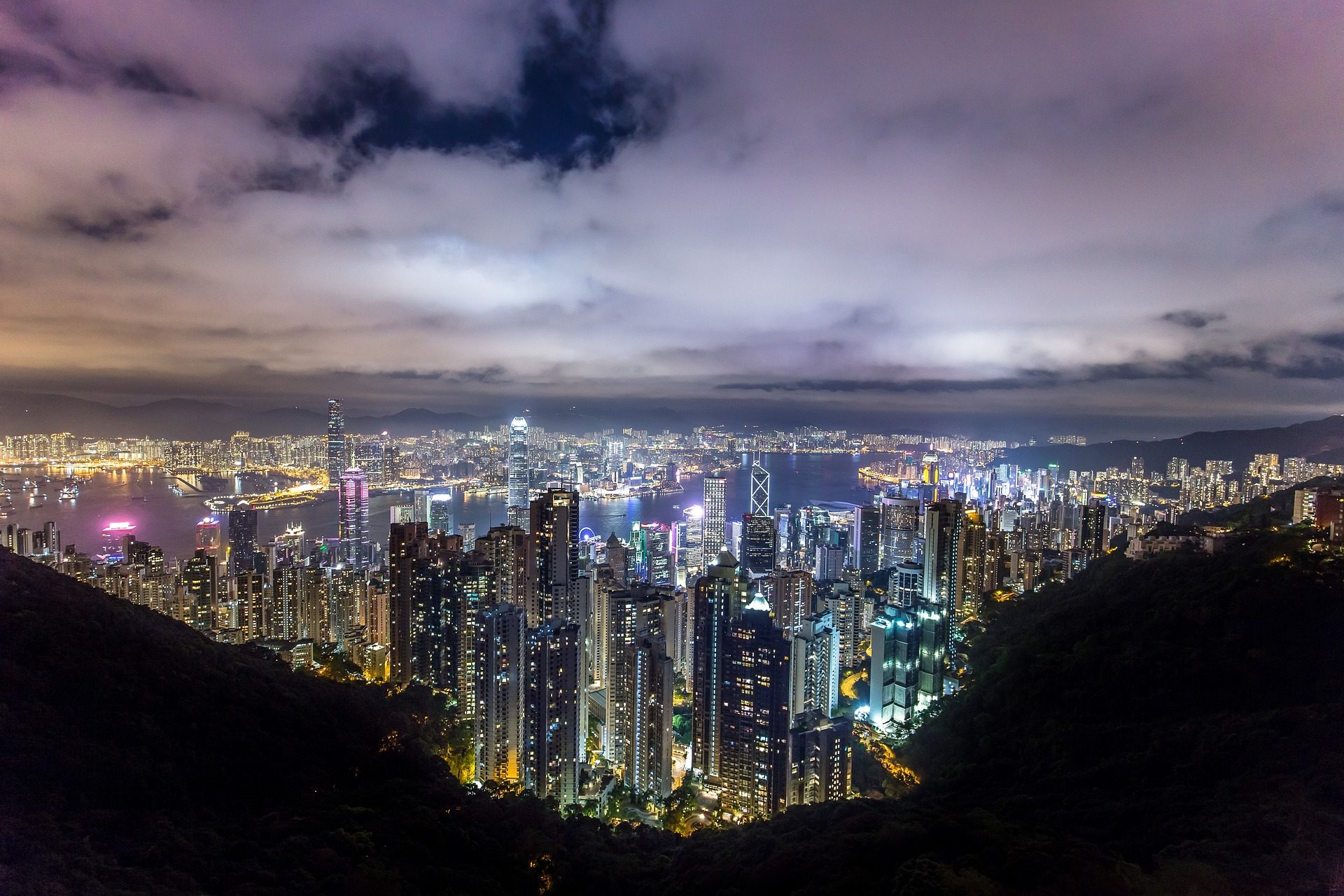 Traditional red-sailed junk boat with Hong Kong skyline behind
