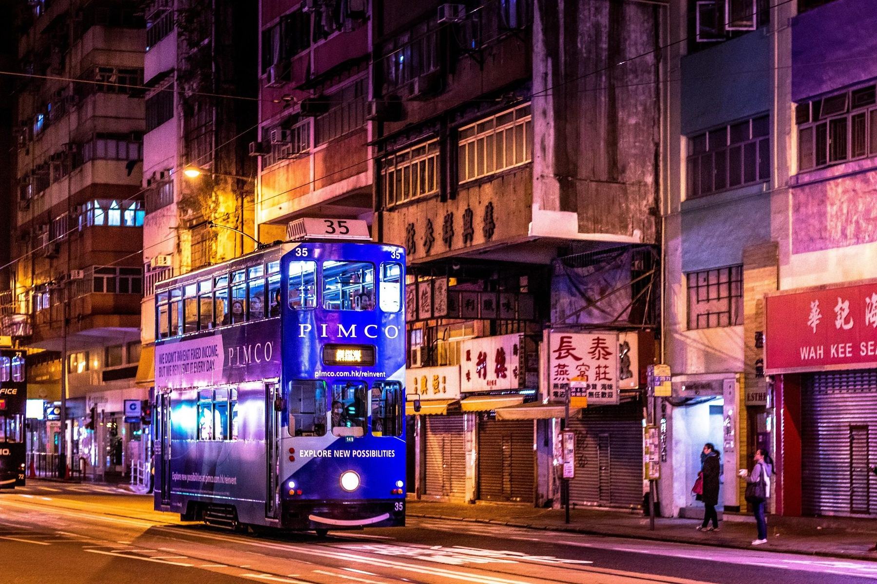 Vintage double-decker tram on a Hong Kong street at night