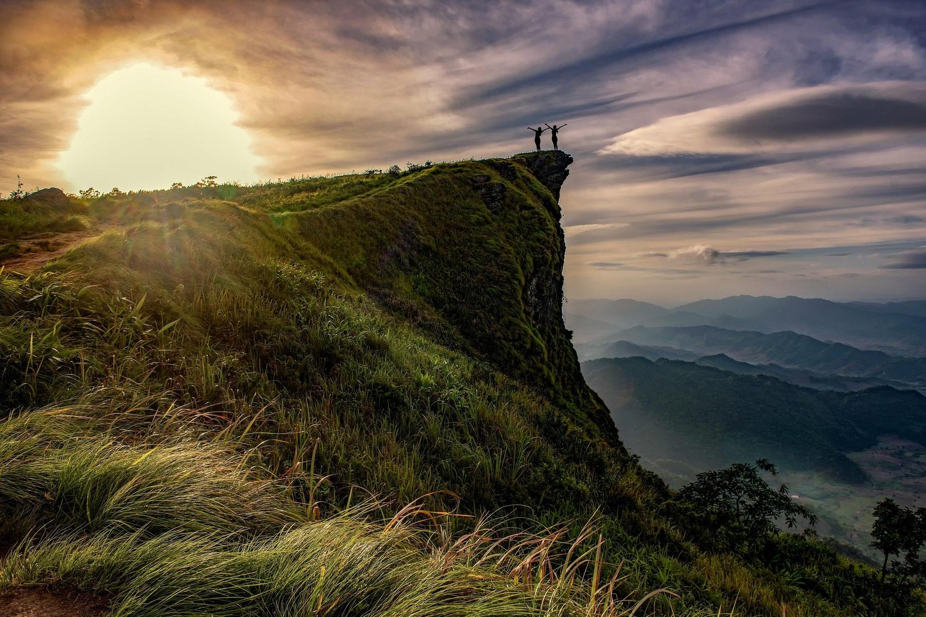 Two travelers on Phu Chi Fa cliff at sunrise, northern Thailand